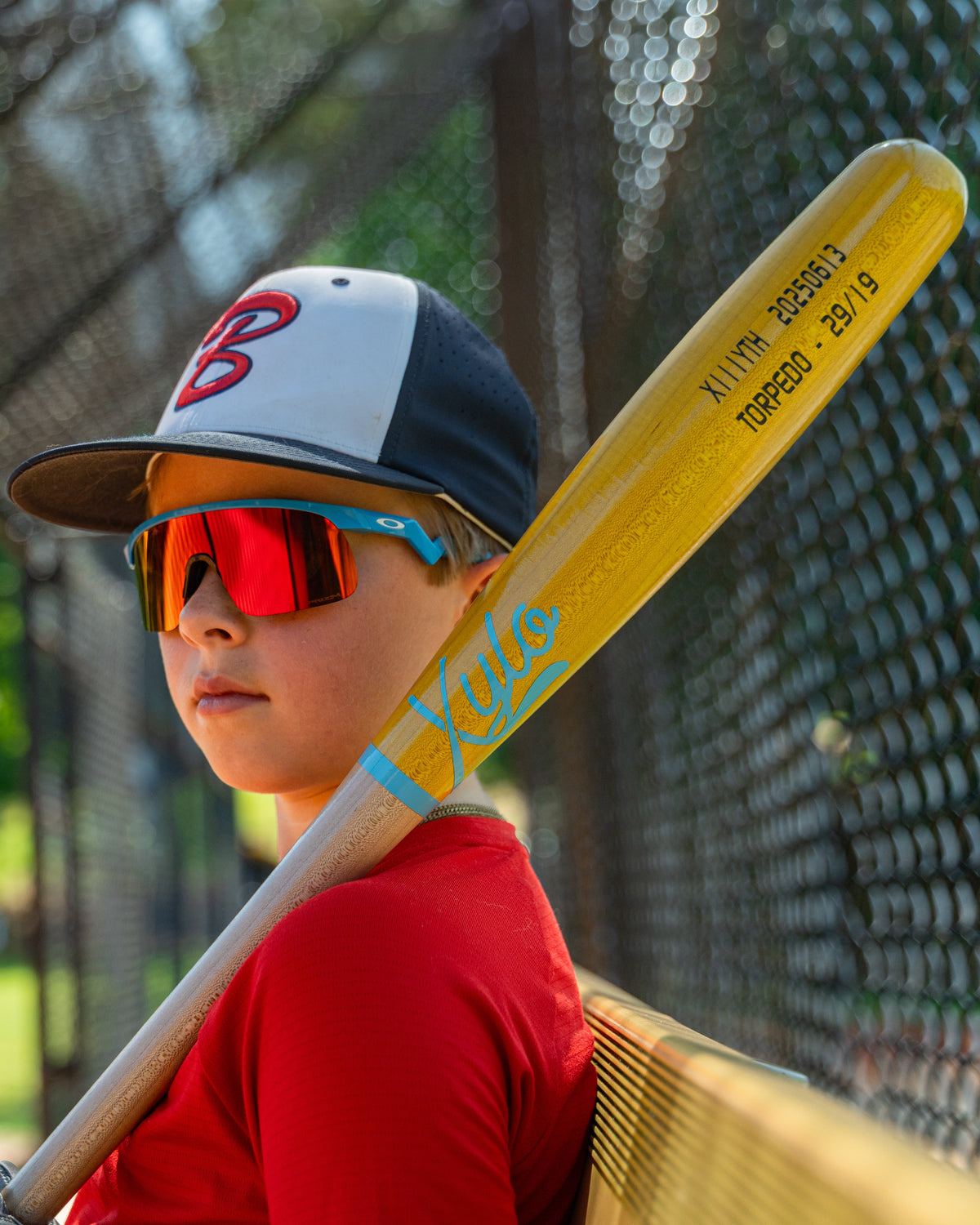 Baseball player holding a Xylo Youth wood baseball bat.