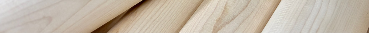Close-up of light natural wood planks with visible grain and a warm beige tone.